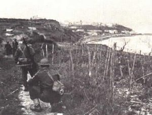 "B" Company of the Seaforth Highlanders look north towards Ortona from the coast road, 21 Dec 1943. PAC photo.